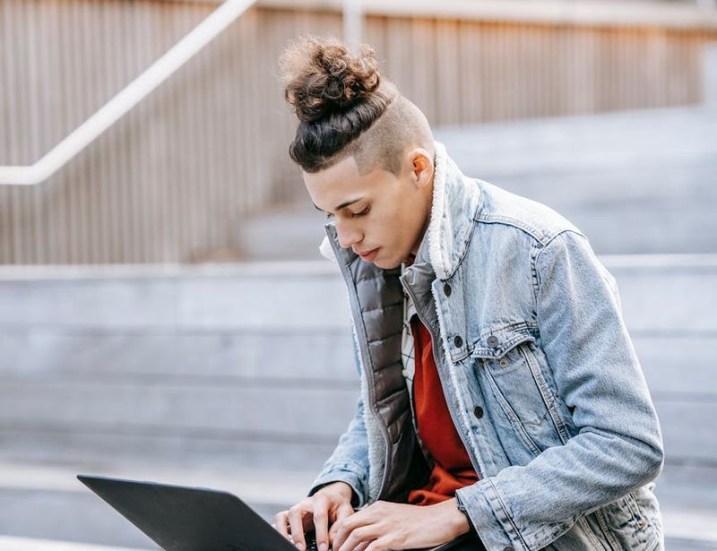 Man in a focused stance during a bodyweight exercise, side view.