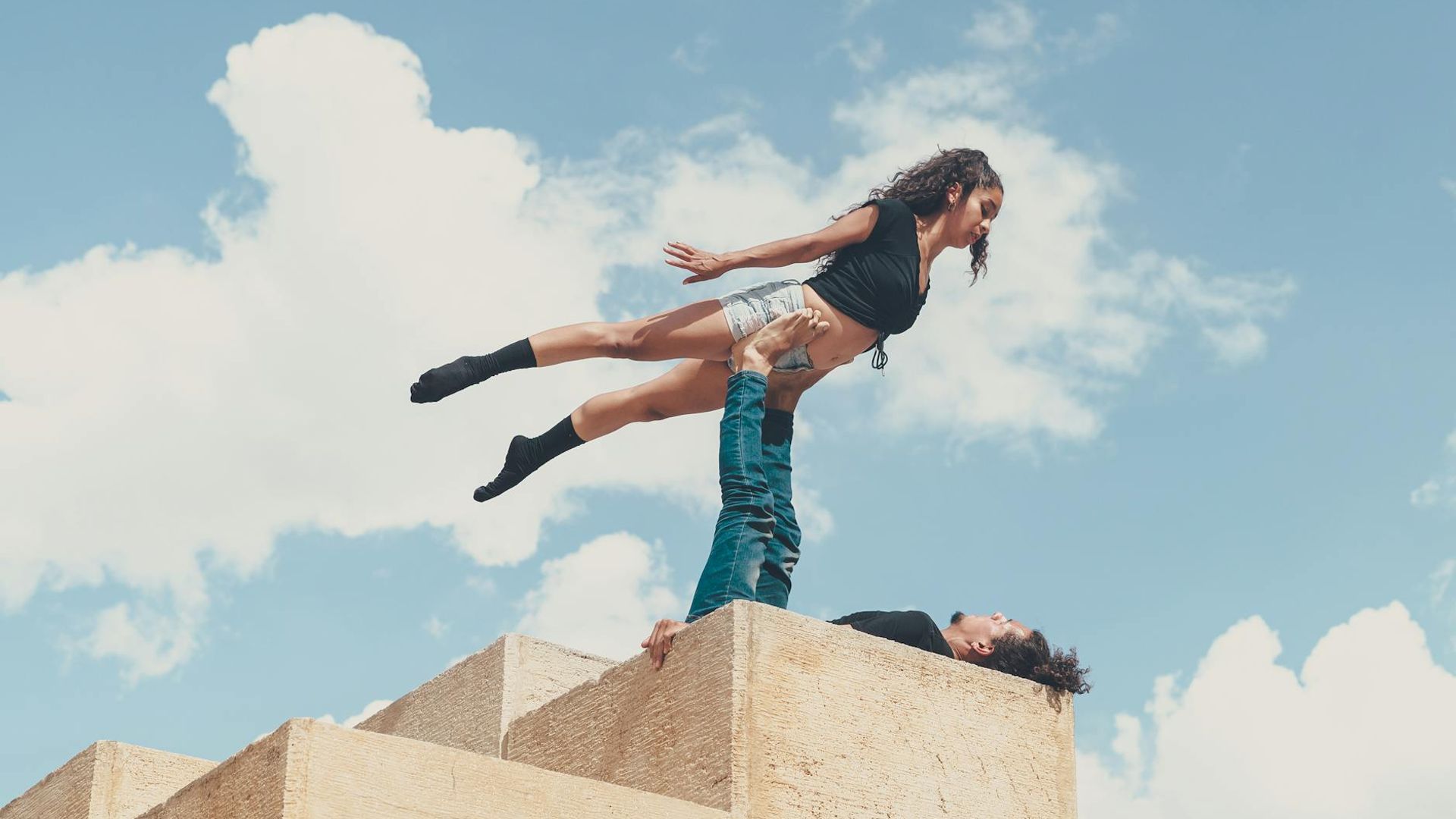 Man performing a controlled strength exercise in a minimalist dark room.
